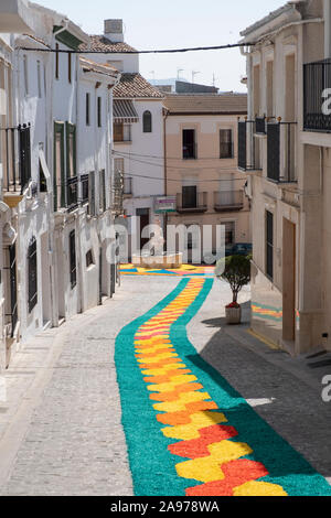 Bunte Teppiche von Holzhackschnitzeln in den Straßen, die von der Gemeinde während der Fronleichnam 2019, Carcabuey, Cordoba, Andalusien. Spanien Stockfoto