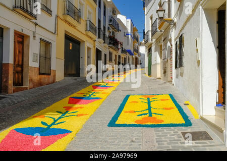 Bunte Teppiche aus Holzhackschnitzeln, die von der Gemeinde während der Fronleichnam 2019 in Carcabuey, Cordoba, Andalusien, in den Straßen gelegt wurden. Spanien Stockfoto