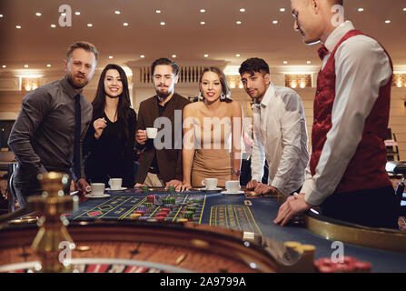 Gruppe von Menschen spielen bei Roulette Poker im Kasino Stockfoto