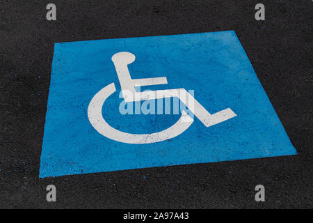 Behindertenparkplätze blau/weißes Schild, auf Asphalt Oberfläche lackiert Stockfoto