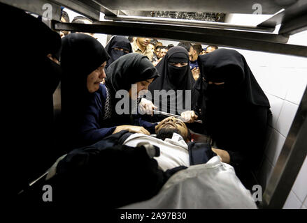 Gaza, Palästina. 13 Nov, 2019. (Anmerkung des Editors: Bild zeigt Tod) Verwandte eines Palästinensischen Mohammed Shurrab, 28, trauern neben seinem Körper in der Leichenhalle des Europäischen Krankenhaus nach einem israelischen Überfall auf ihnen im südlichen Gazastreifen. Credit: SOPA Images Limited/Alamy leben Nachrichten Stockfoto