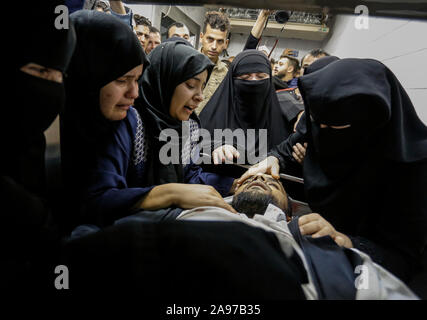 Gaza, Palästina. 13 Nov, 2019. (Anmerkung des Editors: Bild zeigt Tod) Verwandte eines Palästinensischen Mohammed Shurrab, 28, trauern neben seinem Körper in der Leichenhalle des Europäischen Krankenhaus nach einem israelischen Überfall auf ihnen im südlichen Gazastreifen. Credit: SOPA Images Limited/Alamy leben Nachrichten Stockfoto