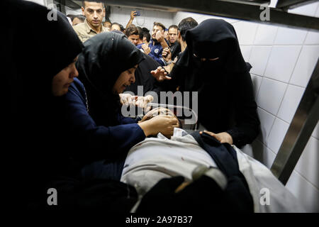 Gaza, Palästina. 13 Nov, 2019. (Anmerkung des Editors: Bild zeigt Tod) Verwandte eines Palästinensischen Mohammed Shurrab, 28, trauern neben seinem Körper in der Leichenhalle des Europäischen Krankenhaus nach einem israelischen Überfall auf ihnen im südlichen Gazastreifen. Credit: SOPA Images Limited/Alamy leben Nachrichten Stockfoto