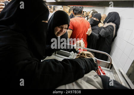 Gaza, Palästina. 13 Nov, 2019. (Anmerkung des Editors: Bild zeigt Tod) Verwandte eines Palästinensischen Mohammed Shurrab, 28, trauern neben seinem Körper in der Leichenhalle des Europäischen Krankenhaus nach einem israelischen Überfall auf ihnen im südlichen Gazastreifen. Credit: SOPA Images Limited/Alamy leben Nachrichten Stockfoto