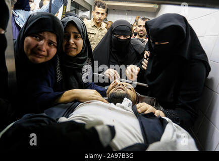 Gaza, Palästina. 13 Nov, 2019. (Anmerkung des Editors: Bild zeigt Tod) Verwandte eines Palästinensischen Mohammed Shurrab, 28, trauern neben seinem Körper in der Leichenhalle des Europäischen Krankenhaus nach einem israelischen Überfall auf ihnen im südlichen Gazastreifen. Credit: SOPA Images Limited/Alamy leben Nachrichten Stockfoto