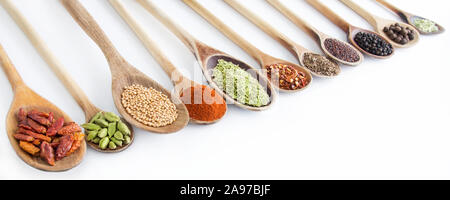 Gewürze und Kochlöffel gegen den weißen Hintergrund Stockfoto