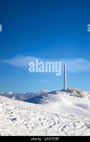 Eisige zellularen Antenne der Basisstation mit Schnee bedeckt. Zelle Aufstellungsort Turm auf moutain Hill. Telefon Netzwerk Transceiver und Kommunikationseinrichtungen auf Stockfoto