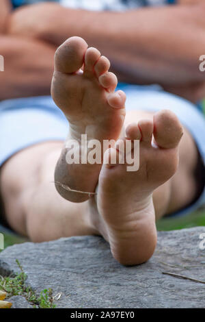 Mann sitzen und entspannen barfuß am Ufer des Flusses Stockfoto