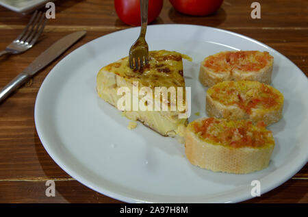 Typische spanische Tapas spanische Tortilla Spieß mit Scheiben Brot mit hohlen Tomaten auf Holzuntergrund... Stockfoto