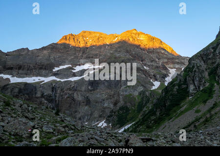 Erste Sonnenstrahlen des Tages toughing die massive, scharfe Stony Mountain Range von Schladming Alpen, Österreich. Der Berg ist teilweise mit grün bewachsenen Stockfoto