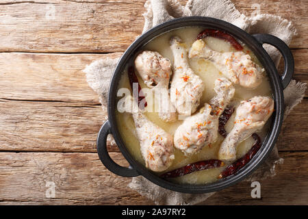 Traditionelle bengali Huhn rezala in weißer Sauce curry mit Chili peppers Close-up in einer Pfanne auf dem Tisch. Horizontal oben Ansicht von oben Stockfoto