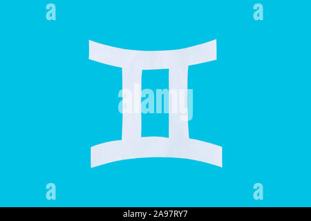 Papier schneiden Horoskop Zeichen Zwillinge isoliert auf einem blauen Hintergrund Stockfoto