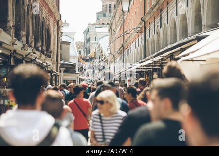 Venedig, Italien, 25. Mai 2019: Menschen zu Fuß durch die überfüllten Straßen von Venedig Rialto Brücke im Hintergrund Stockfoto