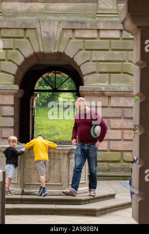 Stockport, Großbritannien - Juli 21, 2019: ein Vater und seine zwei Jungen stehen zu einem Teich am endtrance der Lyme Hall, Lyme Hall historische Englisch stattliche Stockfoto