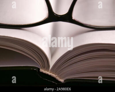 Altes Buch öffnen und Lesebrillen in schwarzen Rahmen, close-up Stockfoto