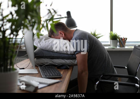Müde Mann am Arbeitsplatz Stockfoto