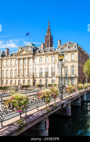 Fassade des Palais Rohan in Straßburg, Frankreich, mit Blick auf die Ill mit dem Turm der Kathedrale Notre-Dame über das Dach ragt. Stockfoto