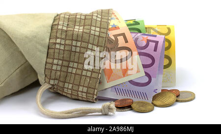 Banknoten und Münzen in der Tasche vor einem weißen Hintergrund Stockfoto