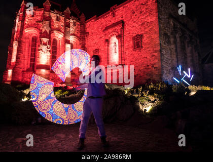 Edinburgh, Vereinigtes Königreich. 13 November, 2019 dargestellt: ein Performer spins Licht Steckt vor der Projektion auf die Burganlage auf der Burg von Licht. Das Edinburgh Castle startet seine Schloss des Lichtes, die vom 14. November bis 22. Dezember 2019. Credit: Rich Dyson/Alamy leben Nachrichten Stockfoto