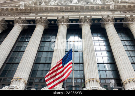 Amerikanische Fahnen Fliegen an der New York Stock Exchange und die Hochhäuser im Hintergrund Stockfoto