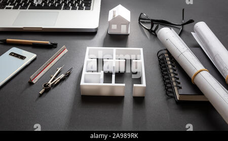 Architekt Ingenieur Büro Schreibtisch. Blueprint Pläne und Haus Modell, Wohnhaus Projekt in Schwarz und Weiß, Nahaufnahme Stockfoto