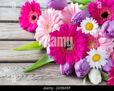 Blumenstrauß gegen Holzbrett Stockfoto
