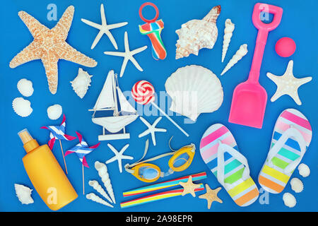 Symbole der Sommer mit Muscheln, Strandspielzeug, Kandis, Strand tragen und Sonnenschutzmittel Schutz Lotion. Sommerurlaub themed Konzept auf blauem Hintergrund. Stockfoto