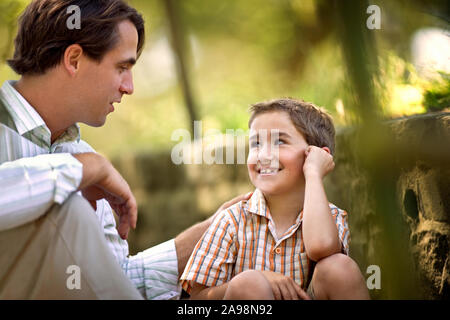 Mitte der erwachsenen Mann im Gespräch mit seinem jungen Sohn. Stockfoto