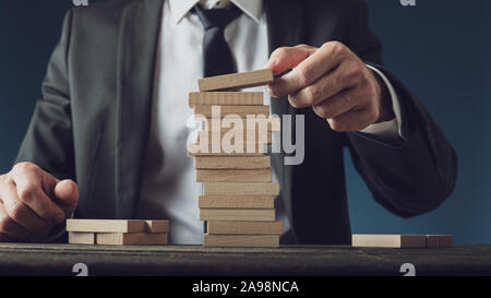 Geschäftsmann stapeln Holzwirbel in einem konzeptionellen Bild des Unternehmens Vision und Starten. Stockfoto