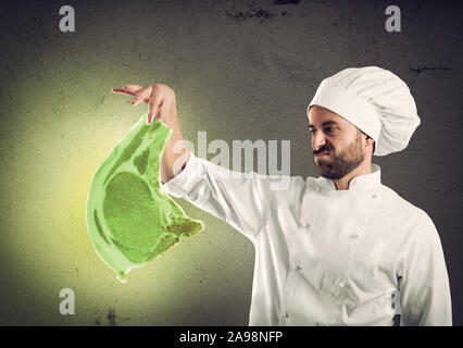 Koch mit radioaktiven und kontaminiertes Fleisch Steak. Konzept der Verschmutzung, ungesund und Schädlichkeit Stockfoto