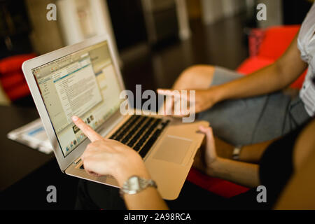 Zwei Frau an einem Laptop Bildschirm angezeigt und per E-Mail hingewiesen. Stockfoto
