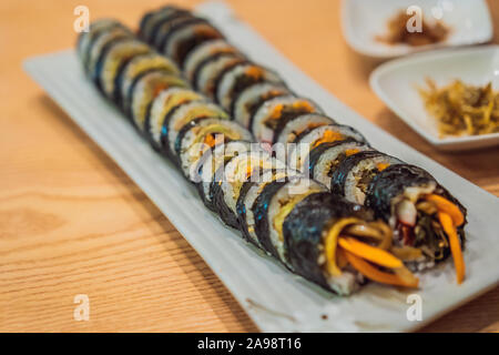 Gimbap oder kimbap ist ein koreanisches Gericht aus gedämpftem Reis bap und verschiedenen anderen Zutaten, die in GIM Blätter getrocknet laver Algen gerollt und Stockfoto