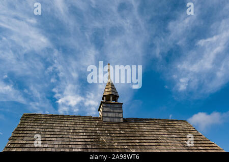 Kapelle alte Holz Fliesen Dach mit Turm gegen Fett blauen Himmel und weißen Wolken Stockfoto