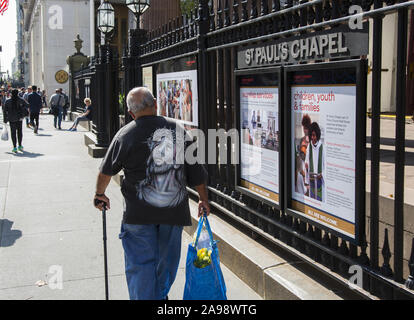 Der Mann mit der Jesus T-shirt Spaziergänge Saint Paul's Chapel auf dem Broadway in der Nähe von Fulton Street in Downtown Manhattan. Stockfoto