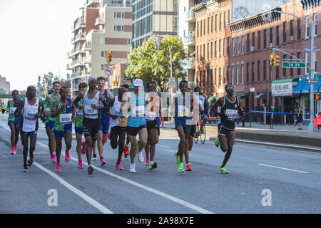 Männliche professionelle Spitzenreiter Kreuzfahrt auf der 4th Avenue in Brooklyn, während der ersten Etappe der 2019 New York City Marathon. Geoffrey Kamworor von Kenia, in der Mitte der 2. Reihe, war der Gewinner zum zweiten Mal in drei Jahren. Stockfoto