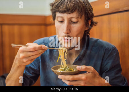 Männliche tourist Essen koreanischen Nudeln in einem koreanischen Cafe. Reisen Korea Konzept Stockfoto