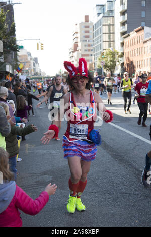 New York City Marathonläufer aus der ganzen Welt durch Nachbarschaft New Yorker entlang der 4th Avenue in Brooklyn, etwa 6 Meile Markierung ermutigt, während der 2019 in New York City Marathon. Stockfoto