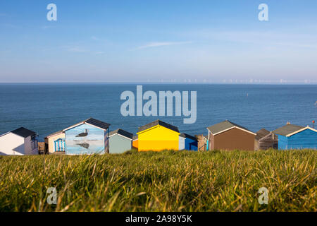 Kent, UK - 21. Februar 2019: Blick auf den Strand, Hütten und Offshore Windparks von der Küstenstadt Tankerton in Kent, Großbritannien. Stockfoto