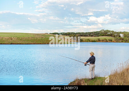 Männliche Rentner Angeln am Ufer der Hopkins River in Victoria, Australien Stockfoto