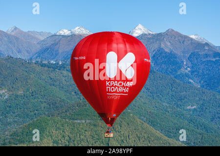 Krasnaja Poljana, Russland - Oktober 13, 2019: Red Hot Air Balloon flight auf dem Berg im Hintergrund. Stockfoto