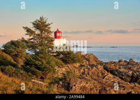 Bei Sonnenuntergang, den Leuchtturm neben dem Wild Pacific Trail in Ucluelet, sitzt auf der zerklüfteten Felsenküste mit Blick auf den Pazifischen Ozean. Stockfoto