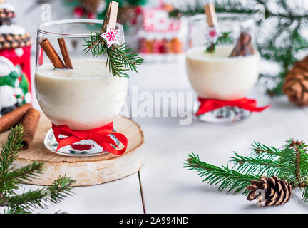 Ein traditionelles Eierlikör Weihnachten Drink in ein Glas Becher dekoriert mit neuen Jahr Wäscheklammer. Nicht-alkoholische Option. Stimmungsvolle Fotos. Stockfoto