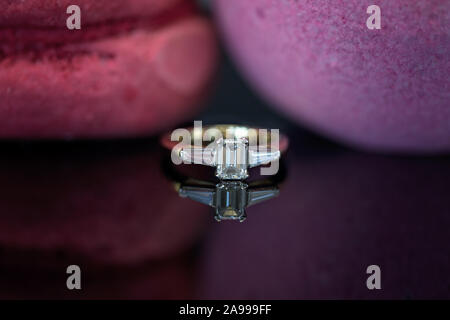 Emerald cut Diamond Ring in Gelbgold auf einem reflectaive schwarze Oberfläche Stockfoto