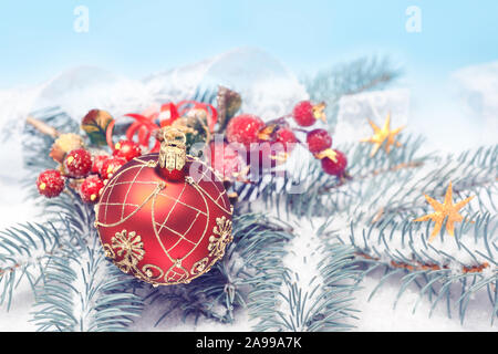 Rote Weihnachtskugel mit goldenen Ornament, dekorative matt Berry und Sterne auf Winter blau weißen Hintergrund mit natürlichen Tannen Zweigen unter Schnee. Frohe Stockfoto