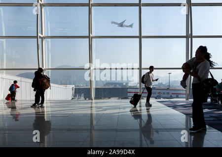 Ein Emirates Cargo Boeing 777-F Frachtflugzeug startet, während Passagiere am Chek Lap Kok Airport in Hong Kong SAR, China, warten. Stockfoto