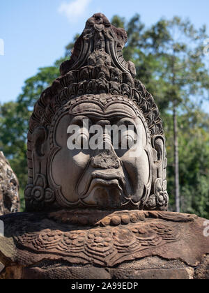 In der Nähe von Angkor Thom in Kambodscha eine Bewachung Statue mit einem gebrochenen Nase und abgeplatzte Kopfschmuck. Stockfoto