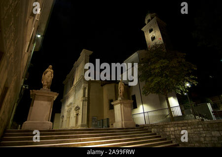 Lugano, Tessin, Schweiz - 25. Juli 2019 - Nacht Blick von der schönen San Lorenzo (St. Lawrence) Kathedrale mit zwei steinernen Statuen über einem stairwa Stockfoto