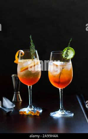 Aperol Stpritz, alkoholfreien Cocktail mit Eiswürfel und Orangenscheiben auf schwarzen Hintergrund. Klassische italienische Aperitif trinken mit Cocktail Zubehör Stockfoto