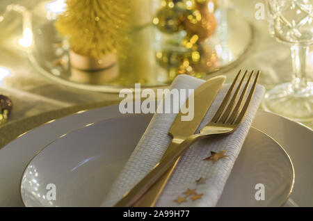 Weihnachten Tabelle Ambiente mit weißen Teller und Besteck Gold. Elegante und festliche Dinner Hintergrund mit kopieren. Weihnachten geschirr Hintergrund. Stockfoto