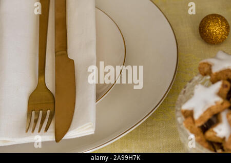 Weihnachten Tabelle Ambiente mit weißen Teller und Besteck Gold. Elegante und festliche Dinner Hintergrund mit kopieren. Weihnachten geschirr Hintergrund. Stockfoto